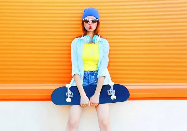 Mode pretty woman med en skateboard är att ha kul över färgglada — Stockfoto