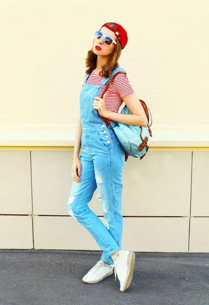 Модная молодая симпатичная женщина в джинсовом комбинезоне поверх белого — стоковое фото