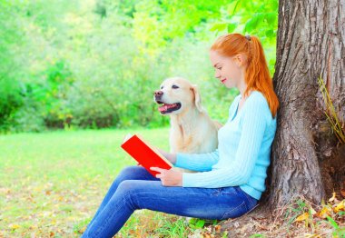 mutlu sahibi kadın Golden Retriever köpek si bir kitap okuyor