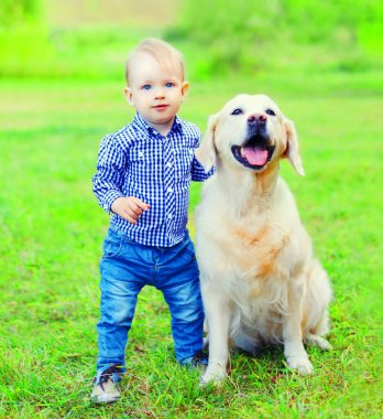 Küçük çocuk çocuk ve Golden Retriever köpek olarak su çim
