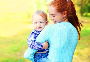 Açık havada bir güneşte gülümseyen mutlu anne ve oğlu çocuk portresi