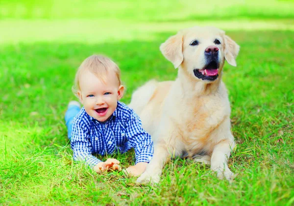 Fröhliches Knabenkind und Golden Retriever Hund liegen zusammen — Stockfoto