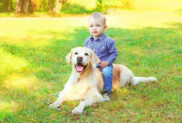 Glad liten pojke barn och en Golden Retriever ljuger hund ihop dem. — Stockfoto