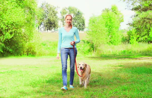 Feliz propietaria mujer con Golden Retriever perro está caminando juntos —  Fotos de Stock