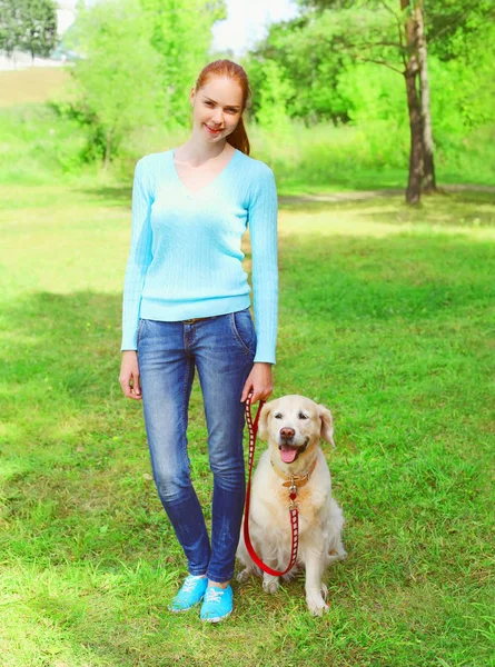 Propietaria mujer con Golden Retriever perro está caminando juntos en un s — Foto de Stock