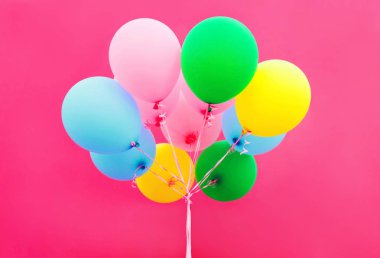 Hava balonları pembe bir arka plan üzerinde renkli paket 