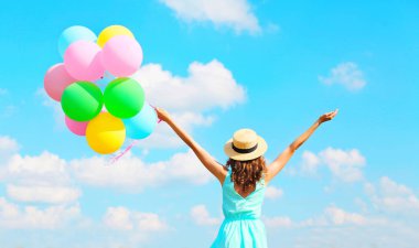 Arkadan Görünüm bir hava renkli balonları ile mutlu kadın zevk 