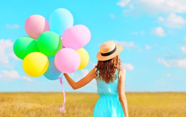 Bir hava renkli balonlar içinde bir hasır şapka enj kadınla arkadan görünüm