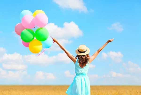 Back view happy woman with an air colorful balloons in a straw h — Stock Photo, Image