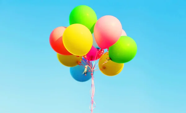 Balões de ar de pacote de fotos coloridas em um céu azul — Fotografia de Stock