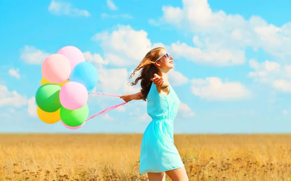 Happy smiling woman running with an air colorful balloons enjoyi — Stock Photo, Image