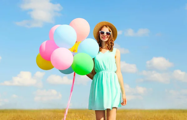 Lyckligt leende ung kvinna håller en air färgglada ballonger avkoppl — Stockfoto