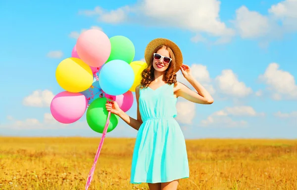 Счастливая улыбающаяся молодая женщина с воздушными красочными воздушными шарами наслаждается — стоковое фото