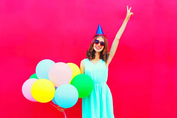 Feliz mujer sonriente en una gorra de cumpleaños divirtiéndose por un cole de aire — Foto de Stock