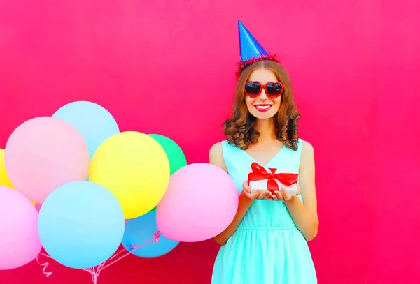 Glücklich lächelnde Frau mit Geburtstagskappe und Geschenkbox auf den Händen, — Stockfoto