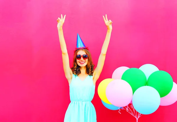 Glücklich lächelnde junge Frau mit Geburtstagskappe, die Spaß bei einem — Stockfoto
