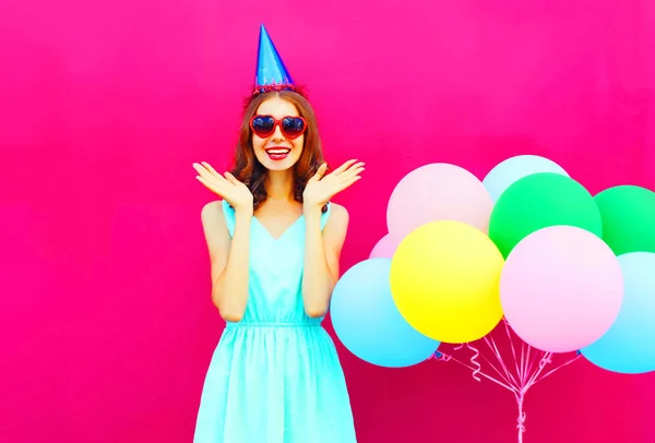 Feliz sorrindo jovem mulher é surpreendida em um boné de aniversário com um — Fotografia de Stock