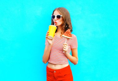 Güzel kadın moda içecekler bir meyve suyu bir fincan tutar dilimden