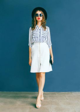 Siyah yuvarlak şapka, beyaz etek ve bir el zarif kadın moda