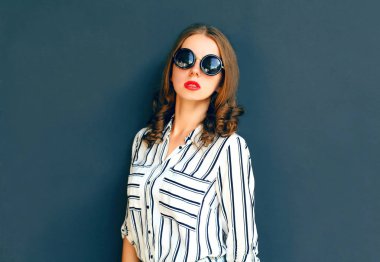 Moda zarif kadın Bayan Ove poz bir siyah güneş gözlüğü takıyor