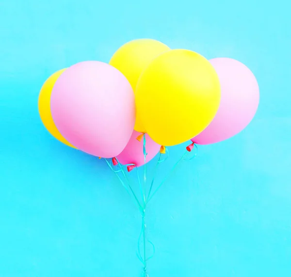 Un paquet coloré de ballons à air sur fond bleu — Photo