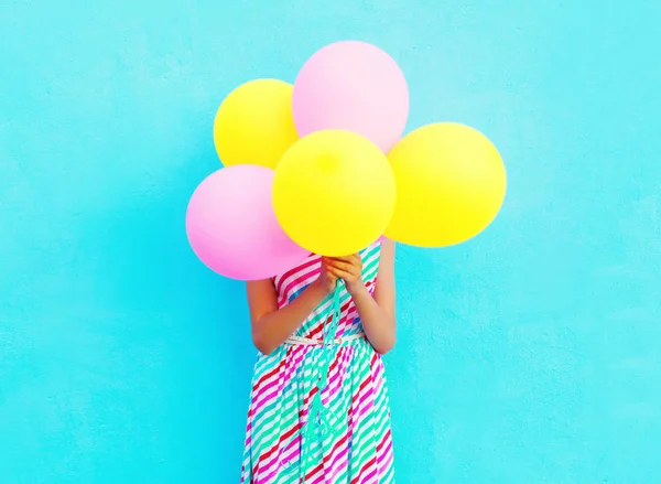 Mulher feliz é esconde sua cabeça um ar balões coloridos com fu — Fotografia de Stock