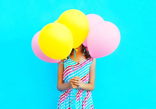 Frau versteckt ihren Kopf in einem luftbunten Luftballon, der Spaß dabei hat — Stockfoto