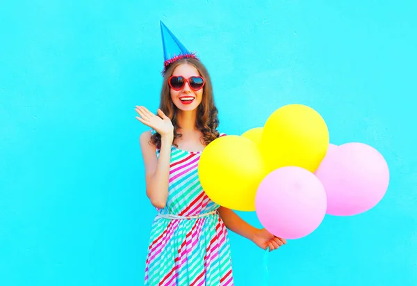 Glada glada leende ung kvinna i en födelsedag mössa med en air c — Stockfoto