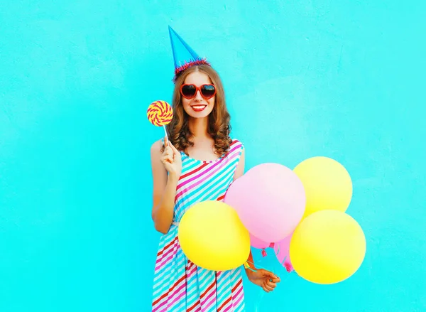 カラフルな空気と誕生日キャップの幸せな笑顔の若い女性 — ストック写真