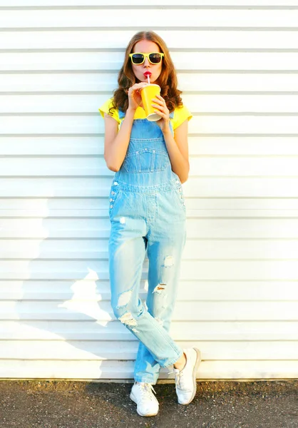 Moda jovem bonita bebe um suco de xícara sobre um branco — Fotografia de Stock
