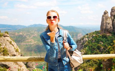 Seyahat genç kadın bir hava öpücük Dağları İspanya backgrou üzerinde gönderir.