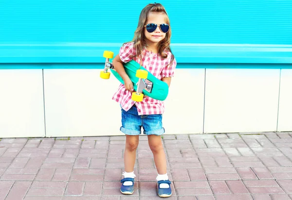 ファッション子供はカラフルなブルー ba の都市でスケート ボードを保持しています。 — ストック写真