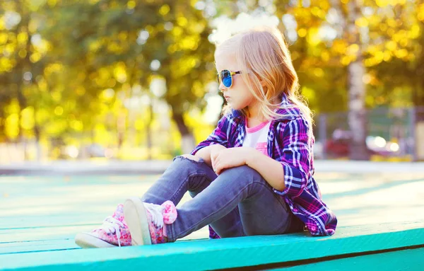 Модный ребенок в солнцезащитных очках и рубашке, сидящий на стуле — стоковое фото