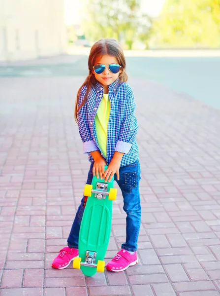 Mode barn liten flicka med skateboard står i staden — Stockfoto