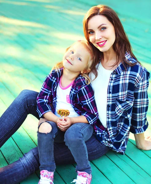 Porträt glücklich lächelnde Mutter und Kind Tochter sitzen auf einem — Stockfoto