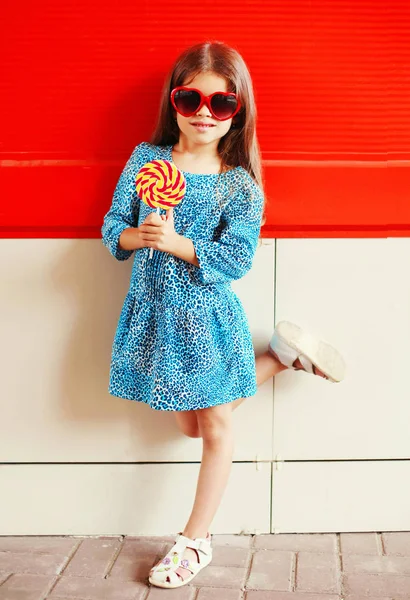 Portrait little girl child with a lollipop stick in leopard dres — Stock Photo, Image