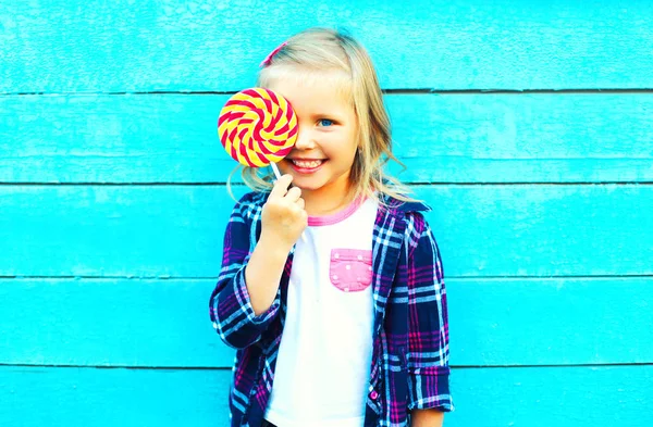 Retrato feliz sonriente niña pequeña con un palillo de piruleta h —  Fotos de Stock