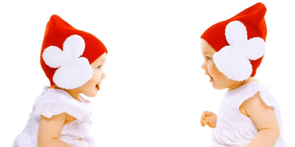 Closeup retrato dois bebês gêmeos em chapéus vermelhos sentado cara a cara — Fotografia de Stock