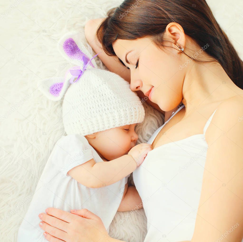 closeup happy young mother sleeping with baby on bed at home, to