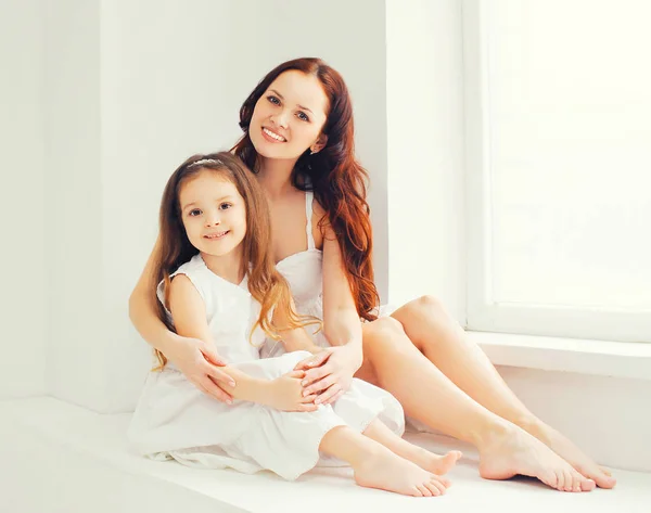 Happy smiling mother and daughter child together at home in whit — Stock Photo, Image