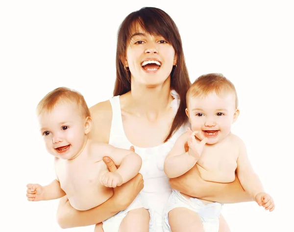 Feliz madre joven con dos bebés gemelos sobre un fondo blanco — Foto de Stock