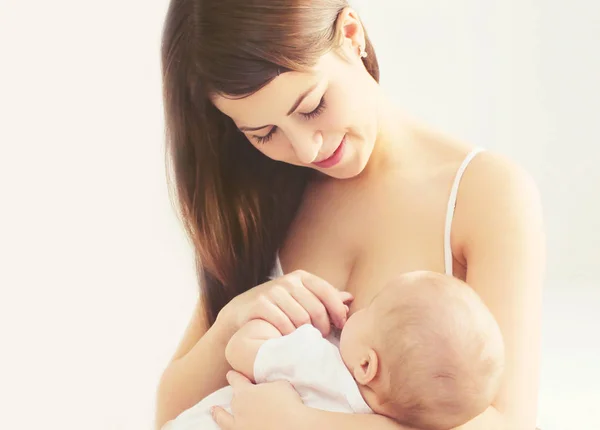 Portret gelukkig lachend moeder voeden van borst haar baby thuis in — Stockfoto