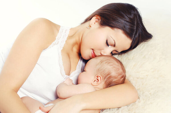 Portrait happy young mother sleeping with baby on bed at home, t