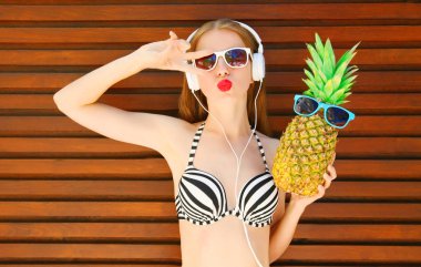 genç ve güzel kadın komik ananas ile baş müzik dinler