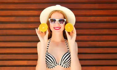 Eller portakal wo üzerinde gülümseyen genç kadın yaz portre tutar