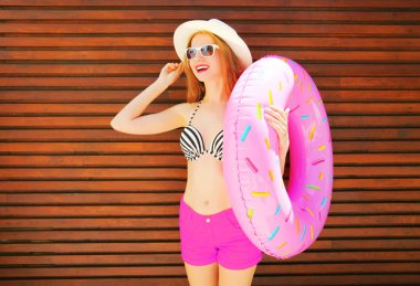 ahşap zemin üzerine şişme yüzüklü oldukça gülümseyen kadın