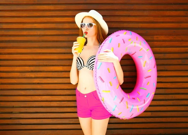 Yaz tatili - kadın şişme halka ile portakal suyu içiyor.