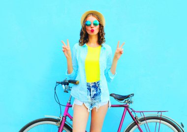 Genç kadın moda ve mavi renkli bir arka plan üzerinde bisiklet