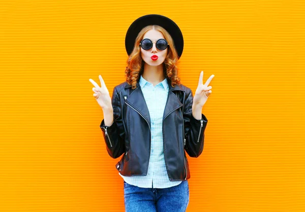 Moda mujer soplando labios en chaqueta de roca negro, sombrero sobre colorf — Foto de Stock