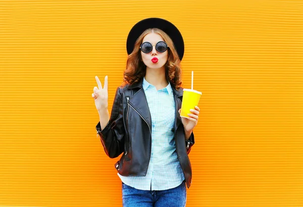 Mujer de moda sostiene una taza de jugo de frutas, chaqueta de roca negro en t — Foto de Stock